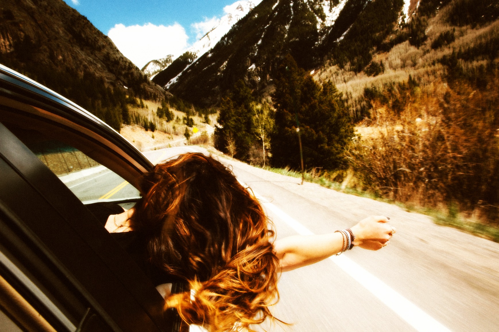Woman-leaning-from-car-window-StockSnap_CMFLFVFD9L-fx
